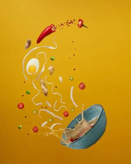 picture of chillies thrown out of a bowl in the air