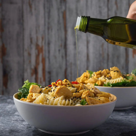 drizzling extra virgin olive oil over pasta